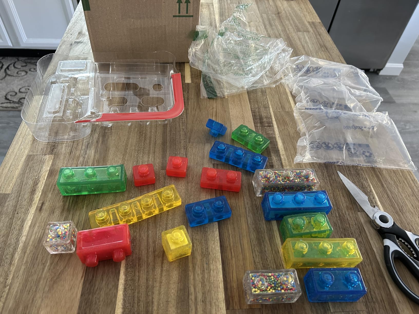 Twenty Creative Kit blocks laid out on a wood countertop next to the emptied packaging