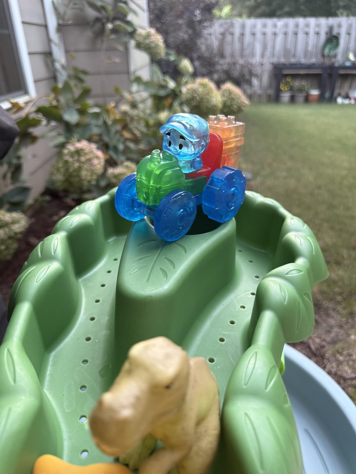 Jelly Blox tractor with the blue farmer parked on a green water table in a backyard